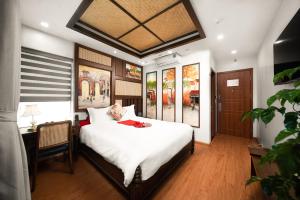 河内Veshia Hotel & Spa的卧室配有一张白色大床和一张书桌