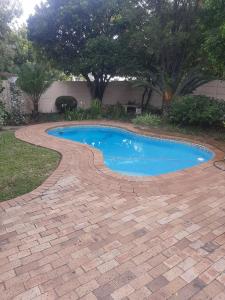 帕尔Sol Montis Guest Cottage的环绕着酒店的砖砌小径的游泳池