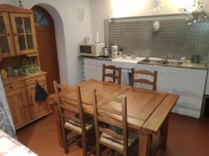 皮耶尔拉特studio chez l'habitant的厨房配有木桌、椅子和水槽