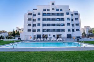 马贝拉Aqua Apartments Bellamar, Marbella的建筑前的一座带游泳池的建筑