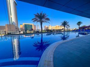 迪拜Exquisite, luxe 1BD Apartment, Unparalleled Sea Views, Prime Dubai Marina Location & Full Kitchen by "La Buena Vida Holiday Homes的一座棕榈树游泳池和城市天际线