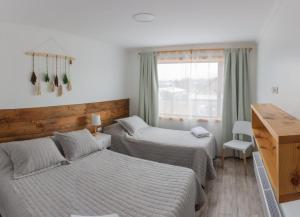 纳塔列斯港Natagonia Apartments的一间卧室设有两张床和窗户。