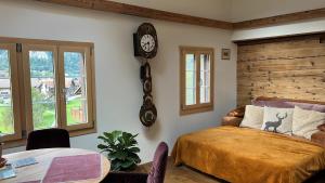 龙疆Romantic private superior Swiss Chalet with Hottub的卧室配有一张床,墙上挂着一个钟