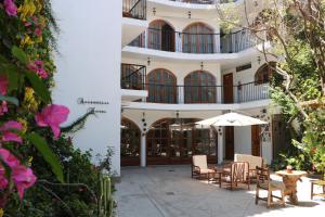 阿亚库乔Astromelia Hotel的一座带椅子和遮阳伞的庭院