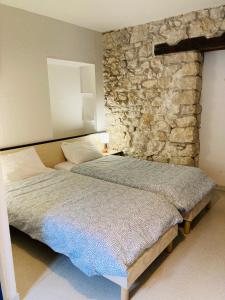 ChorancheLe Jorjane的一间卧室设有两张床和石墙