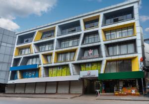 科泽科德KINGS CALICUT的公寓大楼设有黄色和蓝色的窗户。