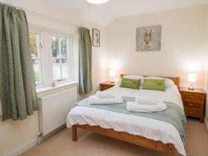 贝克韦尔Lower Cowden Farm的一间卧室配有一张带绿色窗帘的床和窗户。
