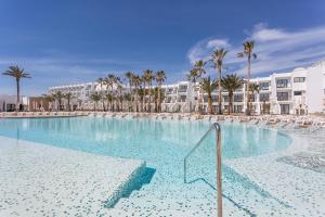 普拉亚登博萨Grand Palladium White Island Resort & Spa - All Inclusive的一座棕榈树和建筑的大型游泳池