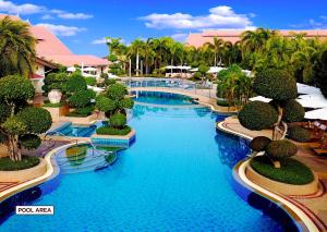 北芭堤雅泰花园度假酒店的拥有蓝水和棕榈树的度假村游泳池