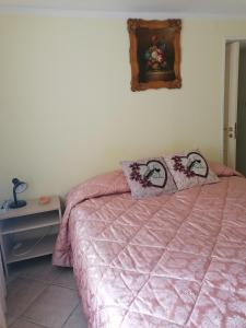 恩纳Apartment Maria的卧室配有粉红色的床和两个枕头