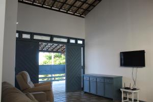 阿拉卡茹Exclusiva Casa na Melhor Praia de Aracaju的客厅设有推拉门和电视。
