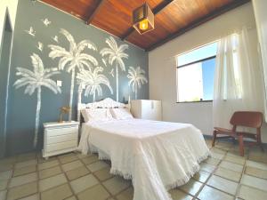 阿拉卡茹Exclusiva Casa na Melhor Praia de Aracaju的卧室配有一张床,墙上种植了棕榈树