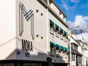 洛里昂MOKA Hôtel的上面有摩西娅标志的白色建筑