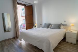 塞维利亚AZZ Sevilla Torre de la Plata Apartamentos的卧室设有一张白色大床和一扇窗户。