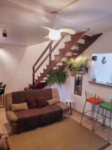 圣塞巴斯蒂安Lindo Flat em Maresias的带沙发和楼梯的客厅