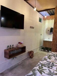 卡利马ADAMA BIOHOTEL的卧室配有壁挂式平面电视。