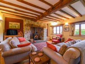 AshreigneyHope Cottage的带沙发和石制壁炉的客厅