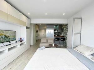 拉科鲁尼亚Skyline Coruña的一间带白色大床的卧室和一间客厅