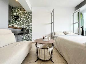 拉科鲁尼亚Skyline Coruña的一间卧室配有两张床和一张钢琴旁边的桌子