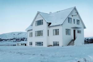 KjarnholtMengi Countryside的雪中白房子,山中