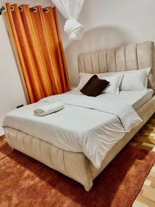 基苏木Ruyer one bedroom的一张大床,配有床头板、白色床单和枕头