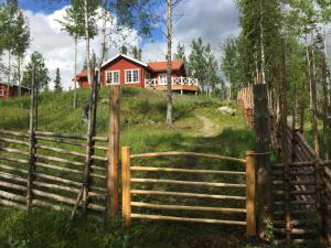 奥勒Mountain Holiday Homes - Ottsjö, Trillevallen -Sweden的树林中房屋前面的围栏