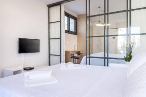 雅典Emilie in Athens - Central chic flat with terrace Syntagma E1的卧室设有一张大白色床和电视。