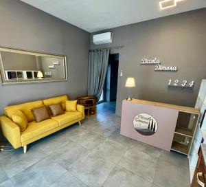 卢卡Piccola Dimora B&B的客厅配有黄色的沙发和桌子