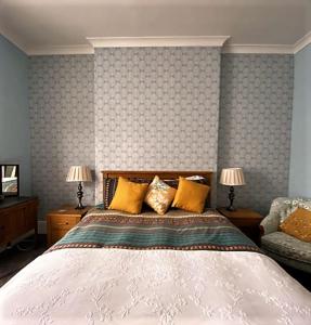 DalrySt John's Flat Spacious Accomodation的一间卧室配有一张床、两盏灯和一张沙发。
