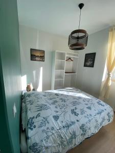 巴斯洛内特Le Côté Cour的一间卧室配有一张带蓝色和白色棉被的床