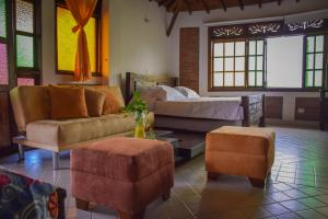 金巴亚Finca Hotel Casa Nostra, Villa Manuela的客厅配有沙发、床和搁脚凳