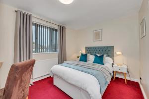 纽马基特The Cambridgeshire的一间卧室设有一张大床和一个窗户。