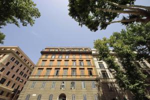 罗马CASTRO PRETORIO SUITE - 1 bedroom flat, 2nd floor with lift, comfortable, quite, central, 2 steps from Termini Railway Station and metro A and B lines, a walk from Colosseum, Trevi Fountain, Spanish Steps, free welcome drinks的一座高大的砖砌建筑,背后是蓝天