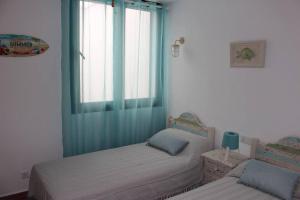 卡兰博希Precioso apartamento en complejo con piscina的一间卧室设有两张单人床和一个窗户。