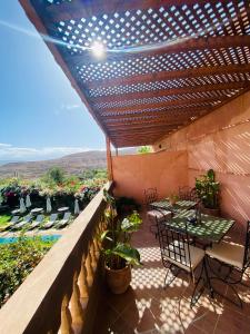 拉拉塔可库斯特Les terrasses du Lac Marrakech的阳台的天井配有桌椅