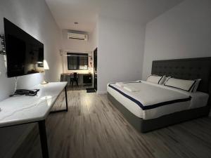 沙湾拿吉Macchiato Resort Savannakhet Opposite Thai Embassy的一间卧室配有一张床、一张书桌和一台电视