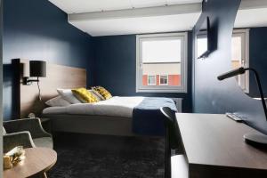 阿沃斯塔尼亚明星贝斯特韦斯特酒店的一间卧室配有一张蓝色墙壁的床和一扇窗户