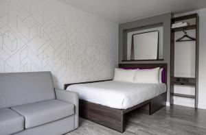 伦敦YOTEL London Shoreditch的一间卧室配有一张床、一把椅子和镜子