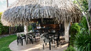 普纳奥亚海滩公寓的茅草屋顶下设有桌椅的餐厅