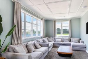 MangakinoLake Maraetai Lodge的客厅配有白色的沙发和窗户。