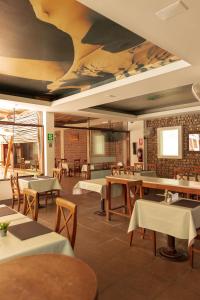 伊察埃尔华卡其内罗酒店的餐厅设有桌椅和天花板上的绘画作品