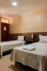 伊察埃尔华卡其内罗酒店的酒店客房,配有两张带白色床单的床
