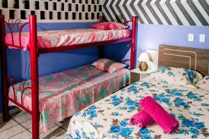 帕尔梅拉斯Pousada Cachoeira da Fumaça的一间卧室配有两张双层床和粉红色床单