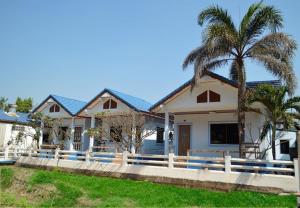 罗勇Pama Resort的白色围栏和棕榈树的房子