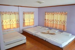 罗勇Pama Resort的带2扇窗户的客房内的2张床