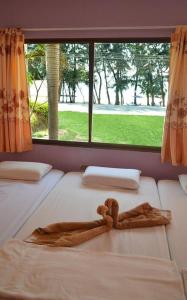 罗勇Pama Resort的带大窗户的客房内的两张床