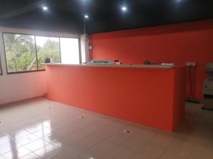 峇都丁宜斯里萨阳度假服务式公寓酒店的一个带橙色墙壁和柜台的办公室