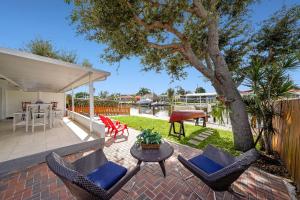 达尼亚滩Dania Beach Waterfront,near Hollywood & Fll的一个带椅子和桌子的庭院和一棵树