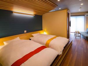 指宿市海老庄酒店的一间带两张床和一张沙发的卧室