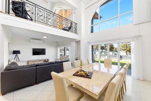 曼哲拉Beachfront Family Favourite Home with Pool & Views的一间带桌子和沙发的用餐室